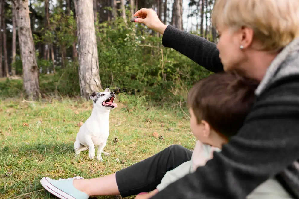 Mère et enfant récompensant leur petit chien pour un bon comportement