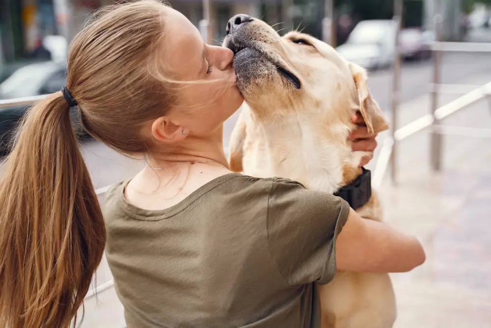 Maîtresse embrassant son chien pour exprimer son affection