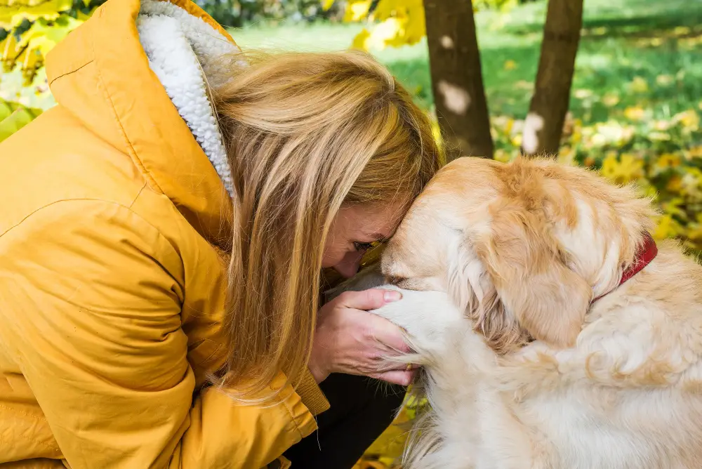 Femme partageant un moment d'affection avec son chien dans la nature